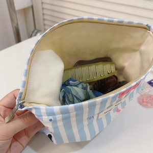 Trousse à maquillage en coton à rayures bleues et blanches montrant le volume intérieur