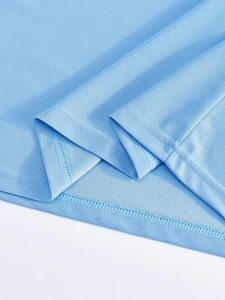 Vue macro de l'ourlet du polo bleu clair montrant la maille respirante et la couture