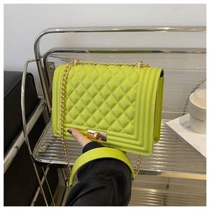 Detail of neon green quilted crossbody bag with gold chain strap and metal lock