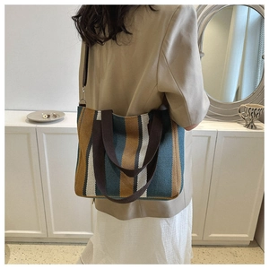 Close-up of a large striped canvas tote bag showing the textured fabric and shoulder strap