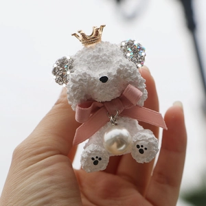 Detailed view of a white teddy bear car vent clip with diamond crown and pink bow