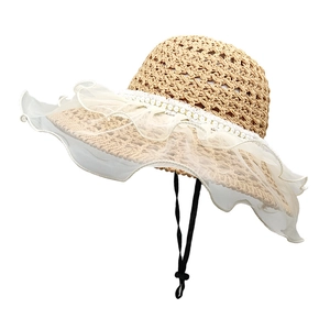 Detail of hollow-out straw hat featuring multilayer lace trim and elegant pearl band decor