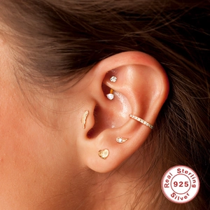 Close-up of 925 sterling silver gold earrings including heart and butterfly designs