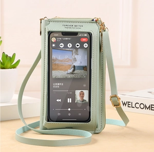 Detail of mint green crossbody phone bag with touchscreen window and litchi grain texture