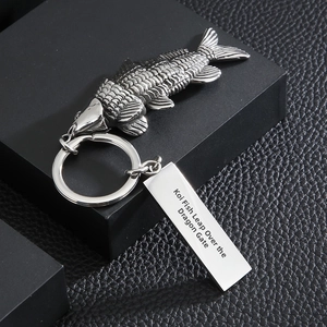 Detailed close-up of antique silver koi fish keychain with engraved metal tag on leather