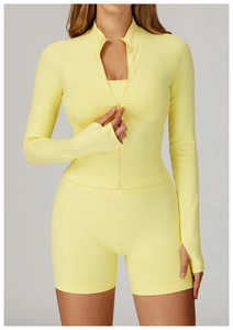 Detail of yellow yoga jacket with thumbholes, stand collar, and ribbed texture fabric
