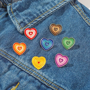Vibrant Y2K gradient heart enamel pins set shown on blue denim jacket style