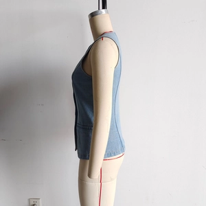 Detailed side view of light blue denim waistcoat featuring metallic buttons and a flat pocket