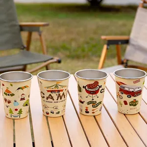 Set of 4 stainless steel camping mugs with cream finish and outdoor illustrations on table