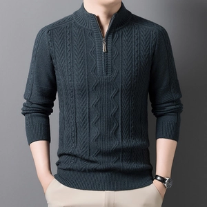 Detail of dark green cable knit sweater featuring a stand collar and half-zip design