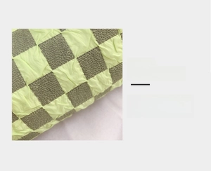 Detail magnification of checkered shoulder bag with 3D wrinkled texture and soft green pattern