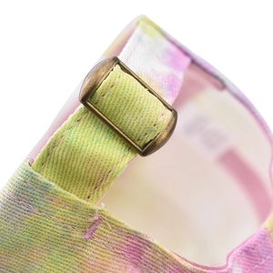 Detail of adjustable metal buckle and colorful watercolor print strap on baseball cap