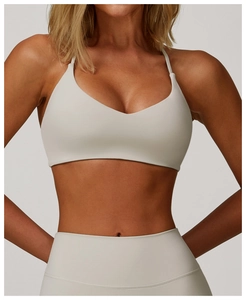 Detail of cross-back yoga bra and seamless leggings in soft beige performance fabric
