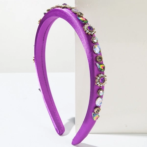 Detail of purple satin headband featuring sparkling colorful rhinestones and vintage floral elements
