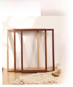 Three natural wood picture frames in oak, light walnut, and dark coffee on a sunny table