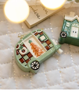Detail of ceramic mint green RV Christmas ornament with hand-painted patterns and gold cord