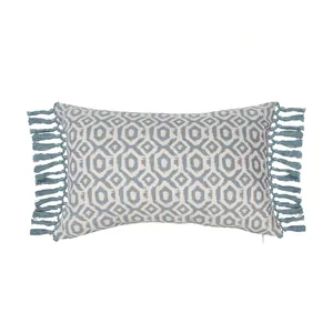 Detail of rectangular pillow cover with blue geometric pattern and fringed side tassels