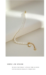 Detail of s925 silver pearl bracelet with starfish and shell charms on white background