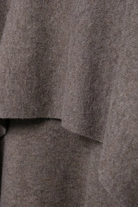 Macro shot showing soft brown knitted fabric texture and warm wool material of the coat