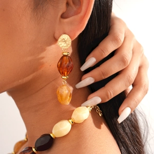 Detail of vintage amber acrylic beaded necklace and earrings on a fashion model