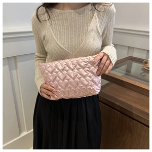 Detail of pink quilted heart pouch with glossy finish shown in a lifestyle setting