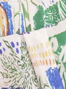 Close-up detail of white fabric with colorful abstract graffiti print and seam textures