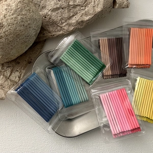 Set of macaron candy colored hair pins in blue and pink on a textured stone surface