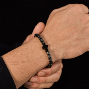 Detailed close-up of a faceted black bead bracelet featuring a flat cross pendant for men