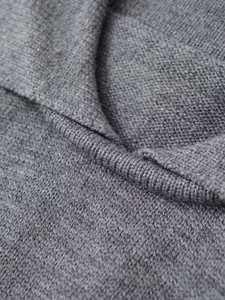 Vista macro dettagliata del top in maglia polo grigio con colletto a costine e trama fine