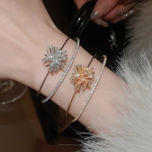 Close-up of sparkling zircon firework double-layered cuff bracelet in gold and silver