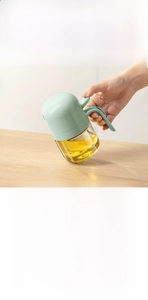 Glass oil dispenser for kitchen, ergonomic push handle for precise oil control and clean use.