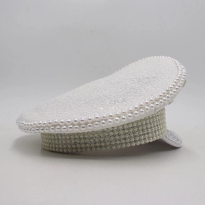 Détail d'une casquette de capitaine blanche avec paillettes et perles pour la mariée