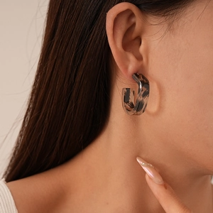 Close-up of leopard print resin C-shaped hoop earrings on a fashion model