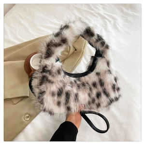 Detail showing plush faux fur crescent bag with stylish black and white spotted patterns