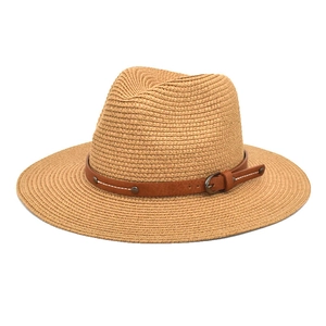 Detail of straw Panama hat featuring a brown leather band with metal buckle and studs