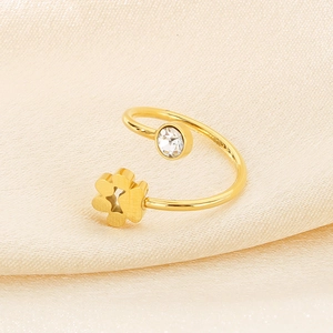 Detailed close-up of golden adjustable flower ring with zircon on beige silk fabric