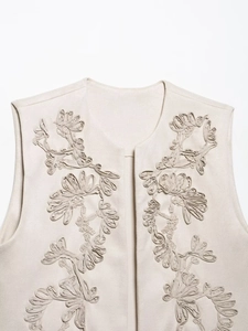 Detailed macro view of 3D floral embroidery on beige suede texture vest for women