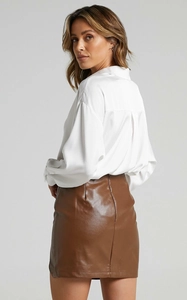 Rear view detail of high-waist brown PU leather mini skirt with a stylish back slit design