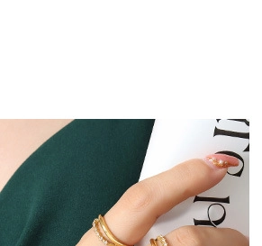Close-up of a gold minimalist band and a thin pavé diamond ring on a hand