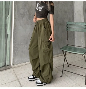 Detail of high-waist drawstring cargo pants in army green with large side pockets