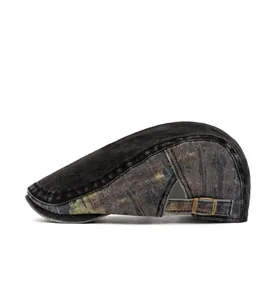 Side view of vintage patchwork denim beret with graffiti print and bronze metal buckle