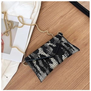 Detailed view of crocodile pattern envelope bag with black and white texture and gold chain