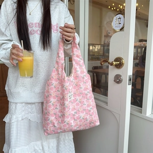 Detailed texture of pink floral quilted tote bag with cute embossed bear pattern