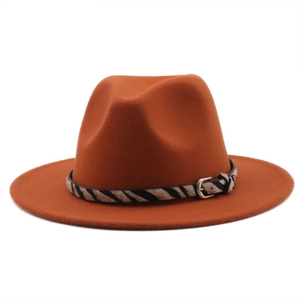 Detail of rust red wool fedora hat featuring a stylish zebra print band and metal buckle