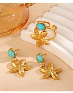 Detail of gold stainless steel starfish jewelry set with inlaid turquoise stones