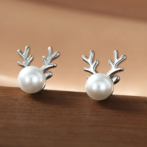 Macro view of elegant deer antler pearl earrings with polished silver texture detail
