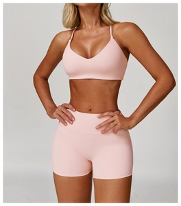 Detail showing the light pink sports bra with deep V-neck and brushed texture fabric