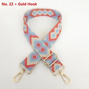 Detail of adjustable woven bag strap with colorful diamond pattern and gold metal hooks