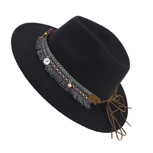 Detail of ethnic embroidery band with tassels and beads on black felt fedora hat