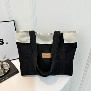 Minimalist canvas tote bag with contrast stitching and leather fashion tag for daily commute